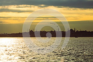 Silhouette of Istanbul at sunset with dramatic cloudy sky and sunlight beams. photo