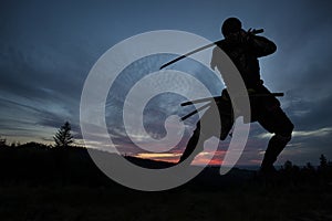 Silhouette of a Japanesesamurai with sword training during sunset