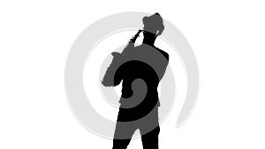 Silhouette jazzman performs solo on saxophone. White background in studio