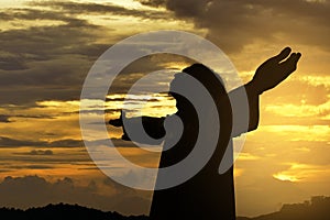 Silhouette of Jesus christ standing with raised arms