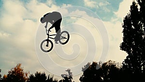 Silhouette of jumper, performing BMX mountain bike