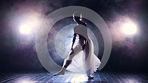 A silhouette of a jumping ballerina on a dark stage.