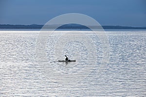 silhouette of a kayak on a large lake