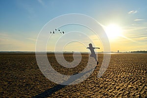 Silhouette of kid running on beach