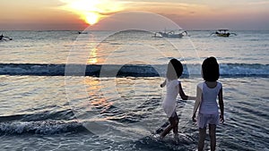 Silhouette of Kids playing in beach during sunset playing with water