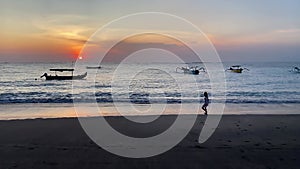 Silhouette of Kids playing in beach during sunset playing with waves