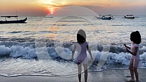 Silhouette of Kids playing in beach during sunset rear view