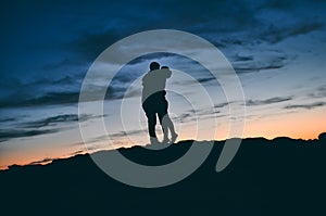 Silhouette of a kissing couple in nature at sunset