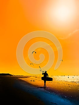 Silhouette of kite surfer against a beautiful sunset. Outdoor Active Lifestyle.