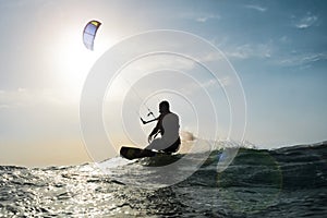 Kite surfer sailing in front of the sunset