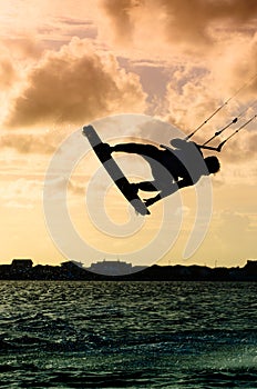 Silhouette of a kitesurfer flying