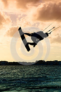 Silhouette of a kitesurfer flying