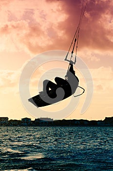 Silhouette of a kitesurfer flying