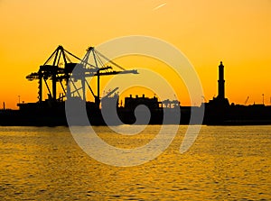 Silhouette of Lanterna lighhouse of city of Genoa Genova, the symbol of the city, in the port at sunset. Italy