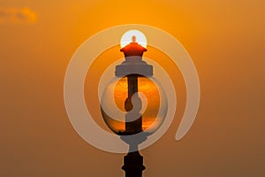 Silhouette light pole with sunrise background