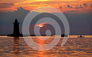 Silhouette of the lighthouse and boats during the sunset at Cape Henlopen State Park, Lewes, Delaware, U.S.A