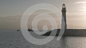 Silhouette of lighthouse with fishing boat
