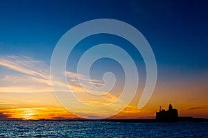 Silhouette of a lighthouse at sunset