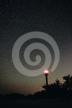 Silhouette of the Lighthouse and trees against the background of the starry sky