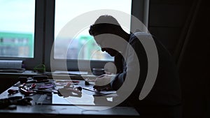 Silhouette of linocut artist in a studio doing lithograph