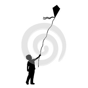 Silhouette little boy flying kite.