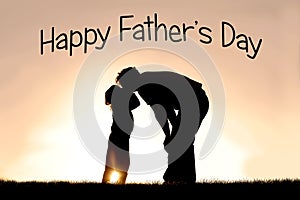 Silhouette of Little Child Kissing her Father at Sunset on a Sum