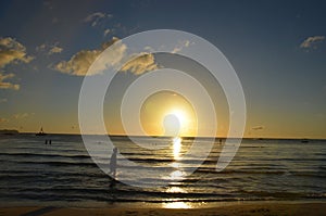 Silhouette of little girl strolling in the beach toward the Sunset