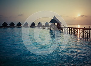 Silhouette of lodges in the sea at sunset. Maldives