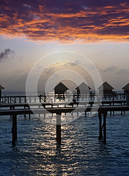 Silhouette of lodges in the sea at sunset. Maldives