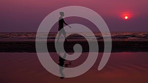 Silhouette. lonely asian young man walking peacefully along a deserted beach at sunset. seascape