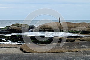 Silhouette of a lonely man looking mysteriously into the dramatic ocean