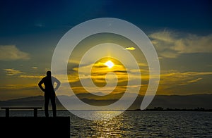 Silhouette,lonely man watching the sea at sunset