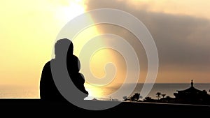 Silhouette Of A Loving Couple Hugging and Kissing Near the Sea on the Balcony at Sunset