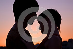 Silhouette of loving couple keeping hands together