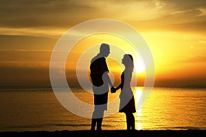 Silhouette of a loving couple at sunset on the seashore