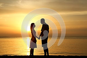 Silhouette of a loving couple at sunset on the seashore