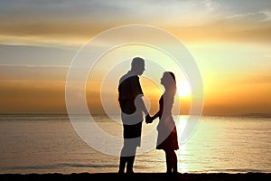 Silhouette of a loving couple at sunset on the seashore