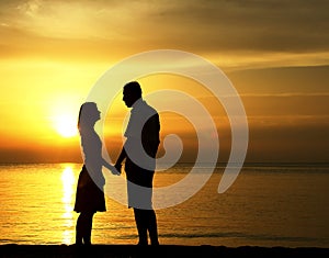 Silhouette of a loving couple at sunset on the seashore