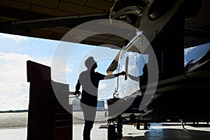 Silhouette Of Male Aero Engineer Working On Helicopter In Hangar