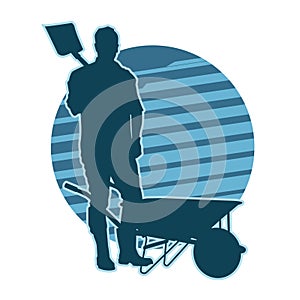 silhouette of a male contruction worker holding shovel and standing near a wheelbarrow.