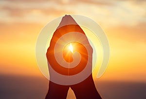 Silhouette of male  raising hands praying for God`s blessings at sunset or sunrise light