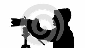 Silhouette of a male videographer with a camera. black and white mask
