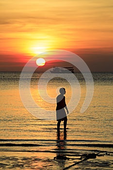 Silhouette of man on beach against beautiful sunset sky