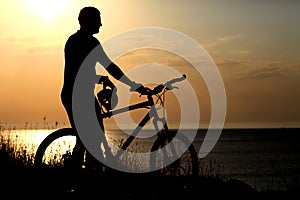 Silhouette of the man with a bicycle