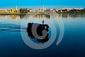 Silhouette of man on boat at unrise on the Nile River, Luxor, Egypt