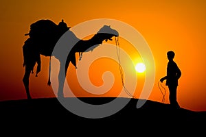 Silhouette of a man and camel