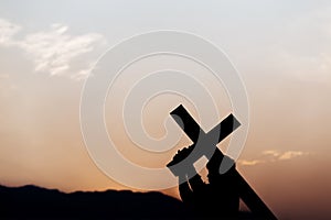 Silhouette of a man carrying a cross at sunset. concept of religion