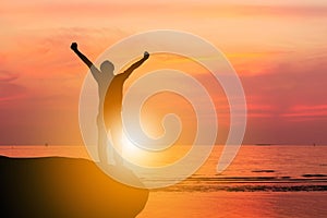 Silhouette of Man Celebration Success Happiness on a Stone Evening Sky Sunset at Beach Background, Sport and active life Concept