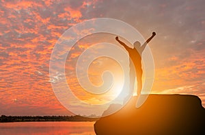 Silhouette of Man Celebration Success Happiness on a Stone Evening Sky Sunset at Beach Background, Sport and active life Concept