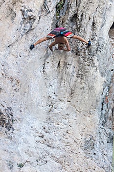 Silhouette of man climbing on rock, mountain at sunset.